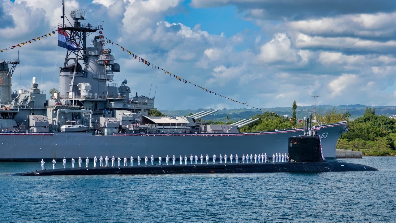 The crew of the Virginia-class fast-attack submarine USS Missouri (SSN 780) render honors to the Battleship Missouri Memorial following a homeport change from Groton, Connecticut. (U.S. Navy photo by Mass Communication Specialist 2nd Class Michael H. Lee/ Released)