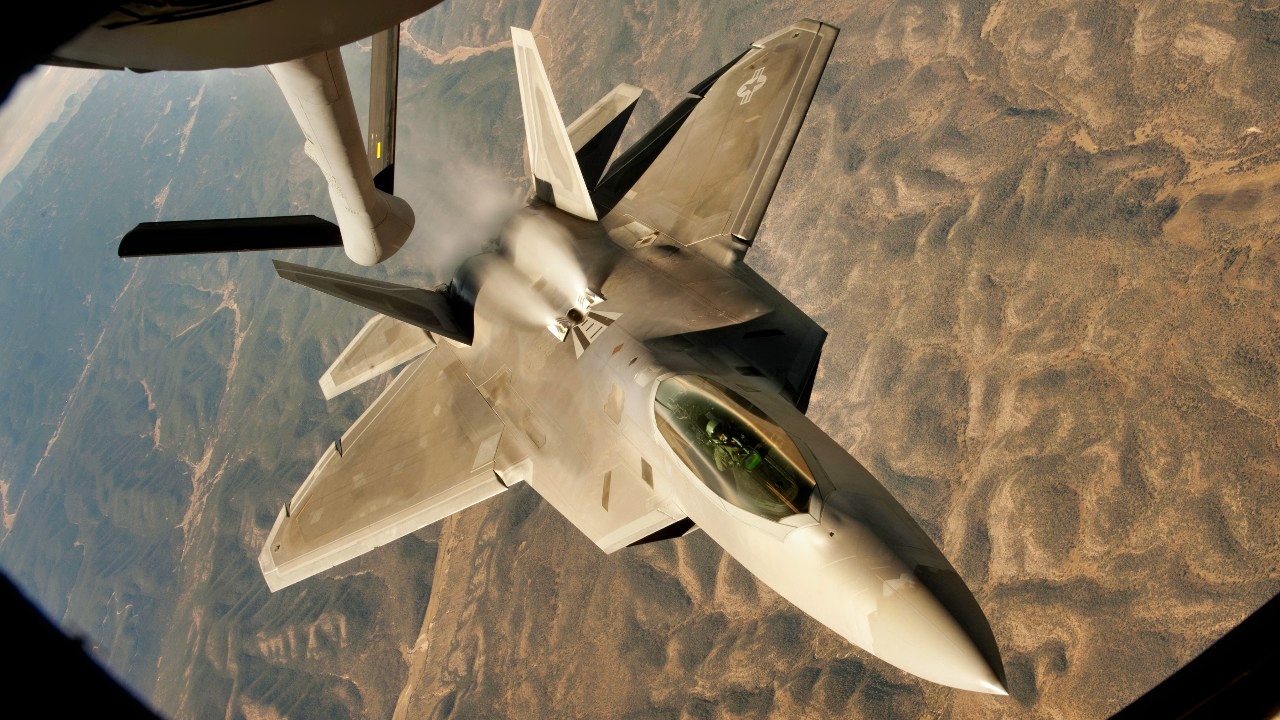 A U.S. Air Force F-22 Raptor backs away from a KC-135 Stratotanker after conducting an in-flight refueling during a training mission over central New Mexico on Oct. 23, 2013. The Raptor is assigned to the 49th Fighter Wing at Holloman Air Force Base, N.M. The Stratotanker is assigned to McConnell Air Force Base, Kan. DoD photo by Airman 1st Class John Linzmeier, U.S. Air Force. (Released)