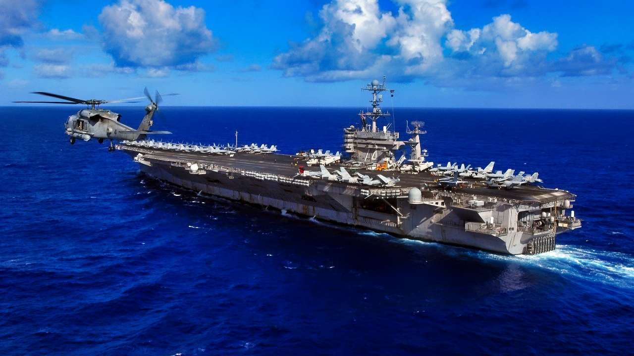 An HH-60H Seahawk, from the "Eightballers" of Helicopter Anti-Submarine Squadron (HS) 8, flies past Nimitz-class aircraft carrier USS John C. Stennis (CVN 74) during flight operations. Stennis is on a scheduled deployment to promote peace, regional cooperation and stability.