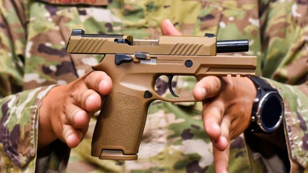 Staff Sgt. Will Gonzales, 36th Security Forces Squadron armory NCO in charge, displays a Sig Sauer M18 pistol on Andersen Air Force Base, Guam, Aug. 26, 2019. The M18 provides improved trigger pull, tritium night sights, larger ammo capacity, weapon reliability and durability to strengthen shooter lethality. (U.S. Air Force photo by Airman 1st Class Michael S. Murphy)
