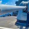 (Aug. 22, 2023) Gunner's Mate 2nd Class Chase Allen maintains the barrel of a Mark 45 5-inch light-weight gun on the fo’c'sle of the Arleigh Burke-class guided-missile destroyer USS Paul Hamilton (DDG 60) in the Pacific Ocean, Aug. 22, 2023. Paul Hamilton is deployed to the U.S. 3rd Fleet area of operations. (U.S. Navy photo by Mass Communication Specialist 2nd Class Elliot Schaudt)