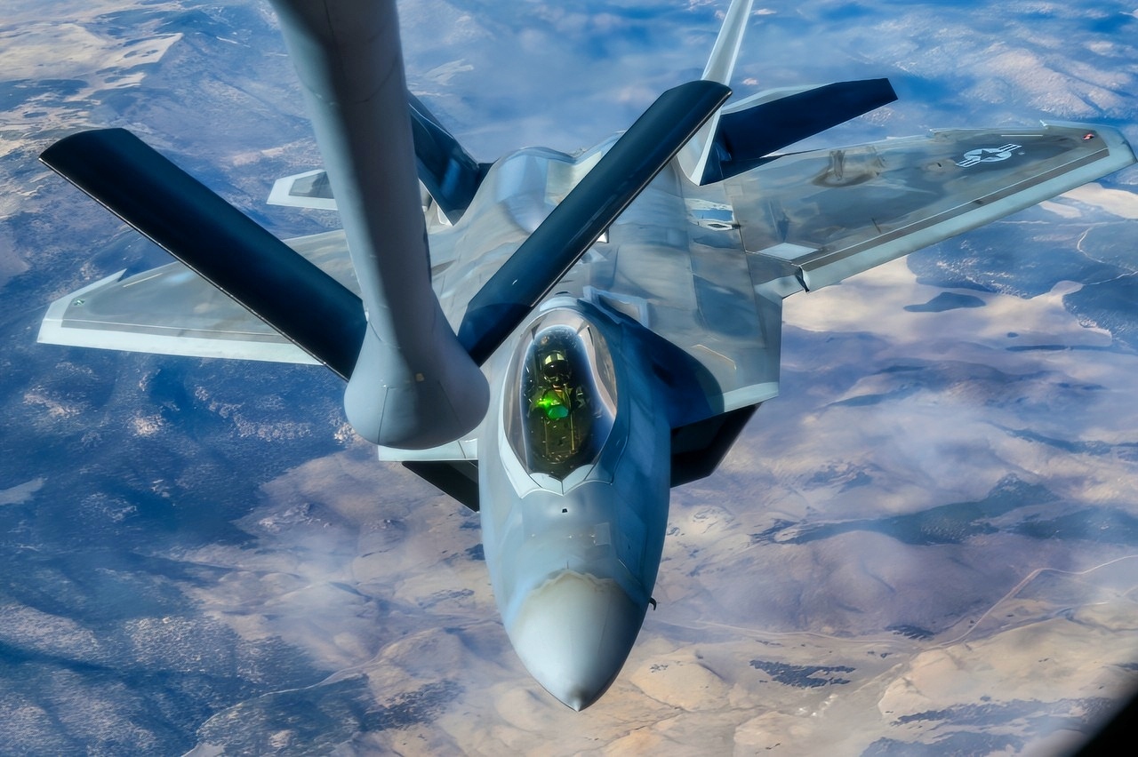 An F-22 Raptor approaches to receive fuel from a KC-135 Stratotanker assigned to the 92nd Air Refueling Wing during the Weapons Integration course over the Nevada Test and Training Range, Dec. 12, 2023. Air refueling crews assigned to the 92nd, 93rd and 97th Air Refueling Squadrons at Fairchild Air Force Base, Washington, participated in the WSINT course to enhance interoperability with a variety of aircraft and demonstrate how Air Mobility Command’s air refueling capabilities enhance global reach for all Department of Defense air operations. WSINT is a series of complex, large-force employment missions that serve as the capstone portion of Weapons School classes, which take place twice a year at Nellis Air Force Base, Nevada. WSINT students plan and execute every aspect of air, space and cyber combat operations, with joint force components converging over the Nevada Test and Training Range. (U.S. Air Force photo by Senior Airman Haiden Morris)