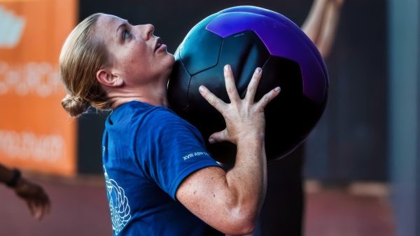 A U.S. Soldier, assigned to Headquarters and Headquarters Battalion, XVIII Airborne Corps, prepares to throw a weighted medicine ball during a physical training session at Segra Stadium in Fayetteville, N.C., July 15, 2025. The full-body exercise was part of a circuit training rotation designed to boost strength and endurance. (U.S. Army photo by Sgt. Gianna Elle Sulger)