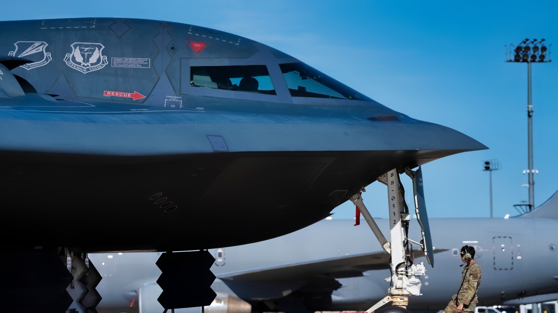 U.S. Air Force Staff Sgt. Hunter Kaloci, 393rd Bomber Generation Squadron crew chief, adjusts a wheel chock in front of a parked B-2 Spirit aircraft at Pease Air National Guard Base, New Hampshire, Sept. 20, 2025. The 393rd BGS provides worldwide combat capability by planning and conducting all aspects of on-aircraft maintenance, launch and recovery of B-2 aircraft in direct support of Joint Chiefs of Staff nuclear and conventional taskings. (U.S. Air Force photo by Staff Sgt. Joshua Hastings)