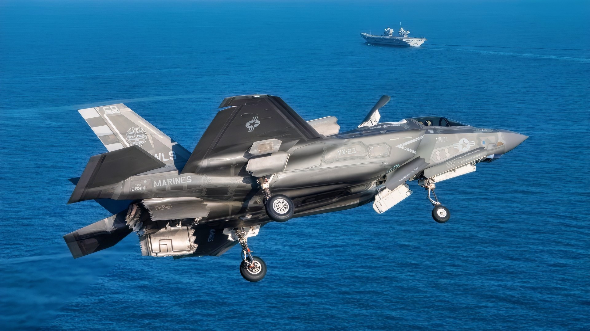 F-35 test pilot Marine Maj. Paul Gucwa from Air Test and Evaluation Squadron Two Three (VX-23), Naval Air Warfare Center Aircraft Division (NAWCAD), flies an F-35B Lightning II fighter aircraft to the U.K. HMS Prince of Wales aircraft carrier in the Western Atlantic Oct. 11, 2023. Gucwa will embark with a detachment from the Patuxent River F-35 Integrated Test Force (ITF) to conduct developmental test phase 3 (DT-3) sea trials with the specially instrumented, short takeoff vertical landing variant of the stealth jet aboard Britain’s largest warship.