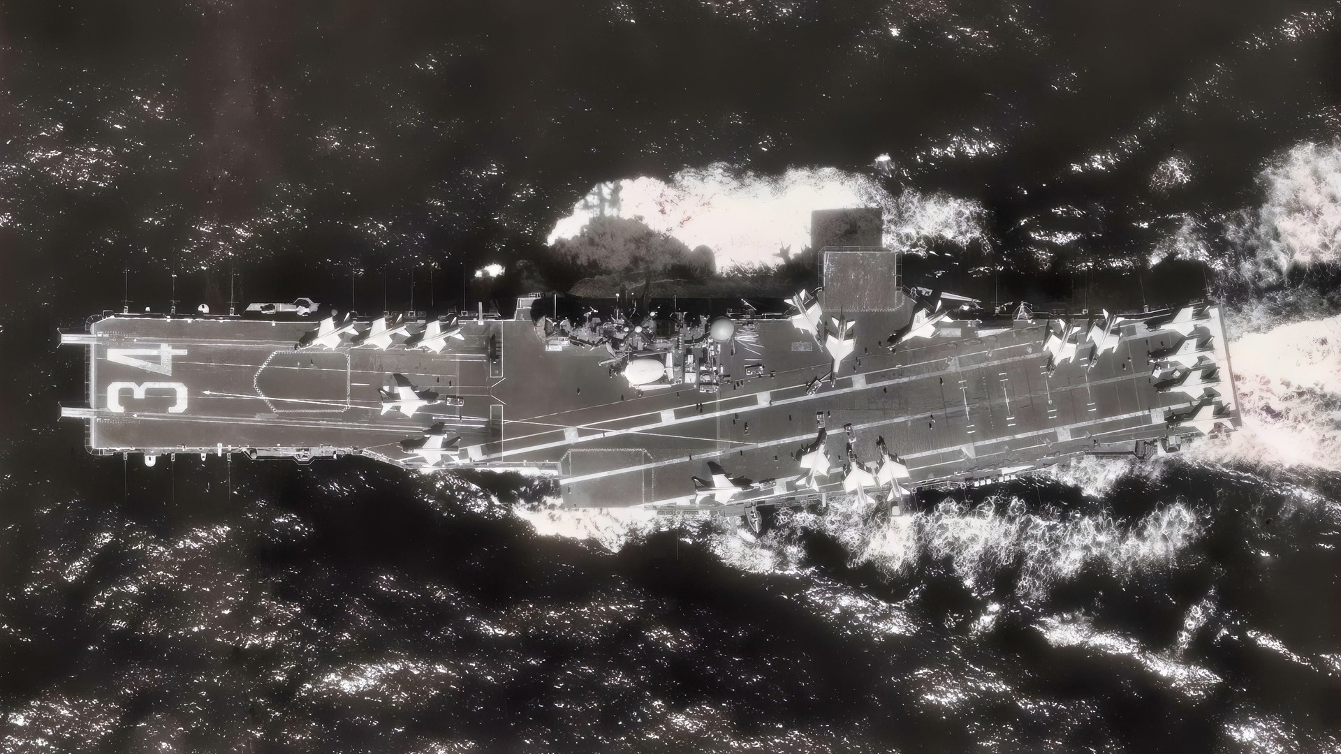 Overhead view of the USS ORISKANY (CV 34). Exact date shot unknown but sometime after March 1964, during this period her flight deck was used to test the E-2 Hawkeye, (seen next to the bridge) then Navy's new airborne early warning aircraft. Note also that there are only LTV F-8 Crusaders on the flight deck, this may put the image as shot between 1975-1976, the last all LTV air wing on its last cruise.