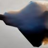 A U.S. Air Force F-22 Raptor emerges from a cloud of vapor during an aerial demonstration at Naval Air Station Meridian, Mississippi, March 27, 2026. The F-22 is designed to perform high-performance maneuvers that showcase its maneuverability and control in flight. The visible vapor forms when rapid changes in air pressure and humidity around the aircraft cause water vapor in the air to condense. (U.S. Air Force photo by Staff Sgt. Lauren Diaz)