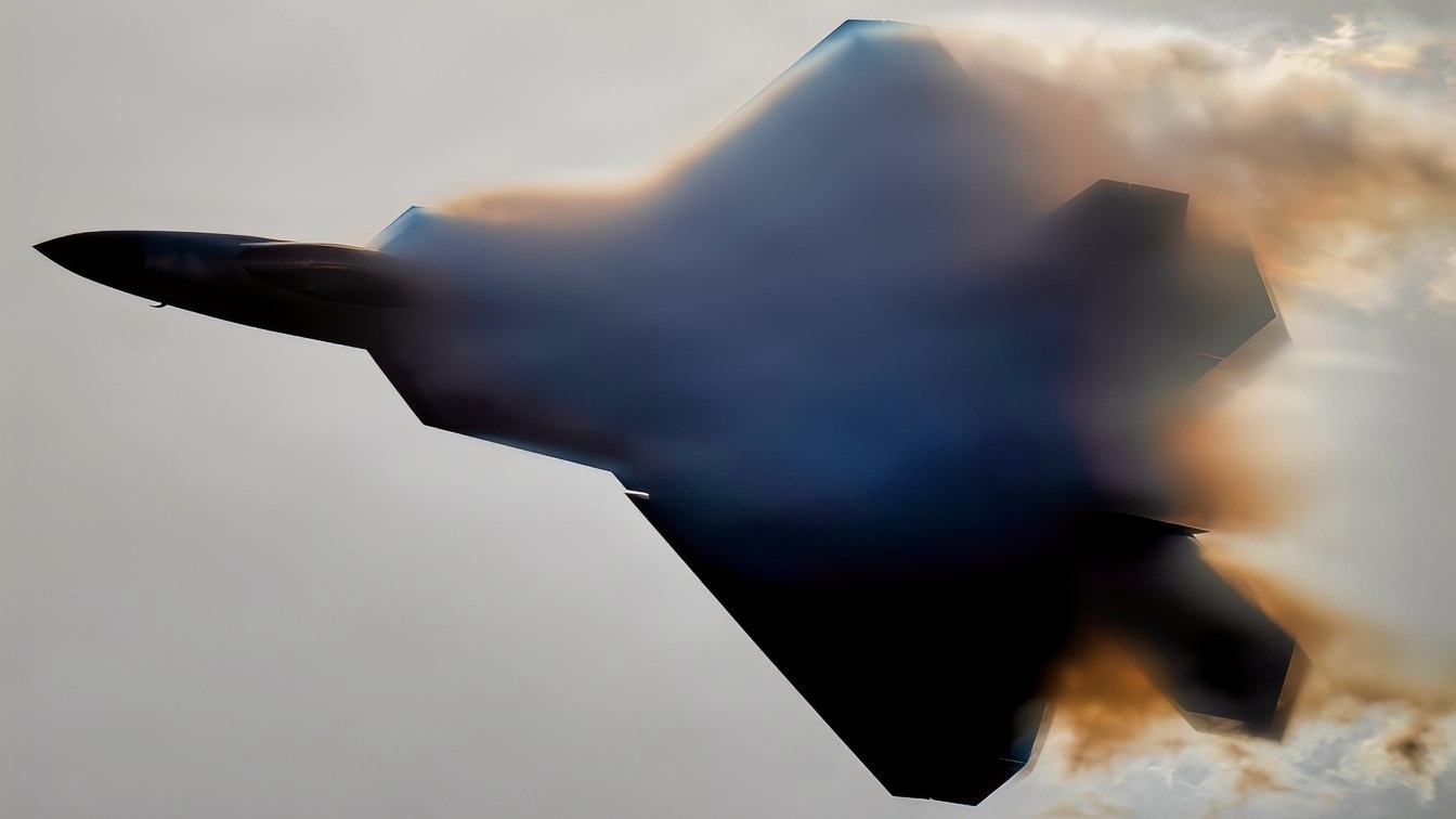 A U.S. Air Force F-22 Raptor emerges from a cloud of vapor during an aerial demonstration at Naval Air Station Meridian, Mississippi, March 27, 2026. The F-22 is designed to perform high-performance maneuvers that showcase its maneuverability and control in flight. The visible vapor forms when rapid changes in air pressure and humidity around the aircraft cause water vapor in the air to condense. (U.S. Air Force photo by Staff Sgt. Lauren Diaz)